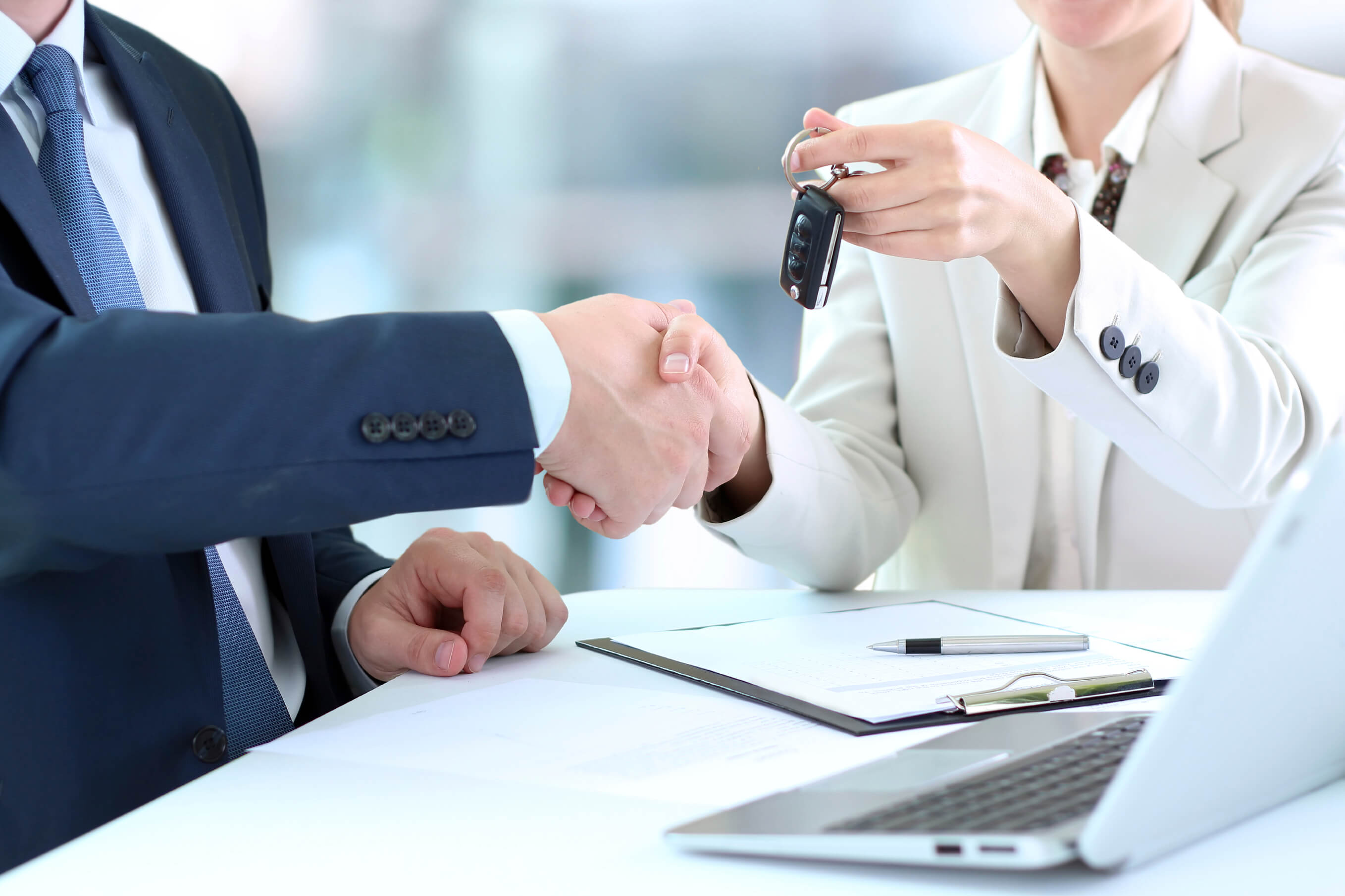 car salesperson handing over keys