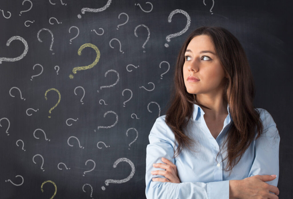 office worker against blackboard filled with question marks