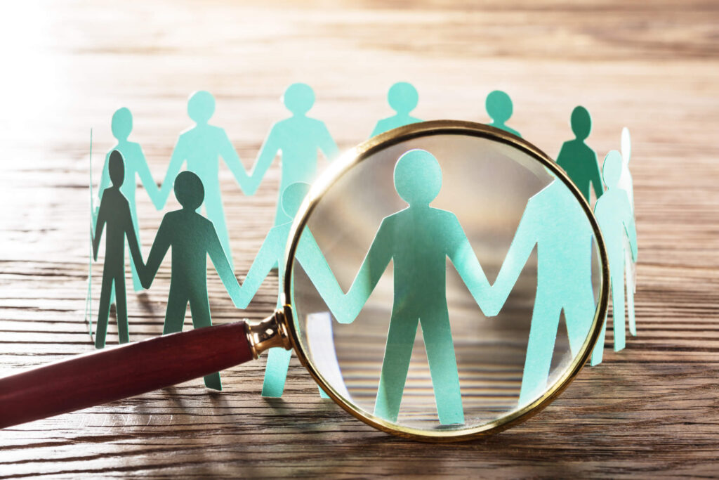 magnifying glass and paper human figures