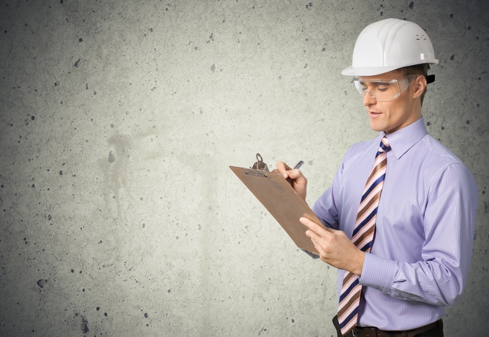 person at construction site with clipboard