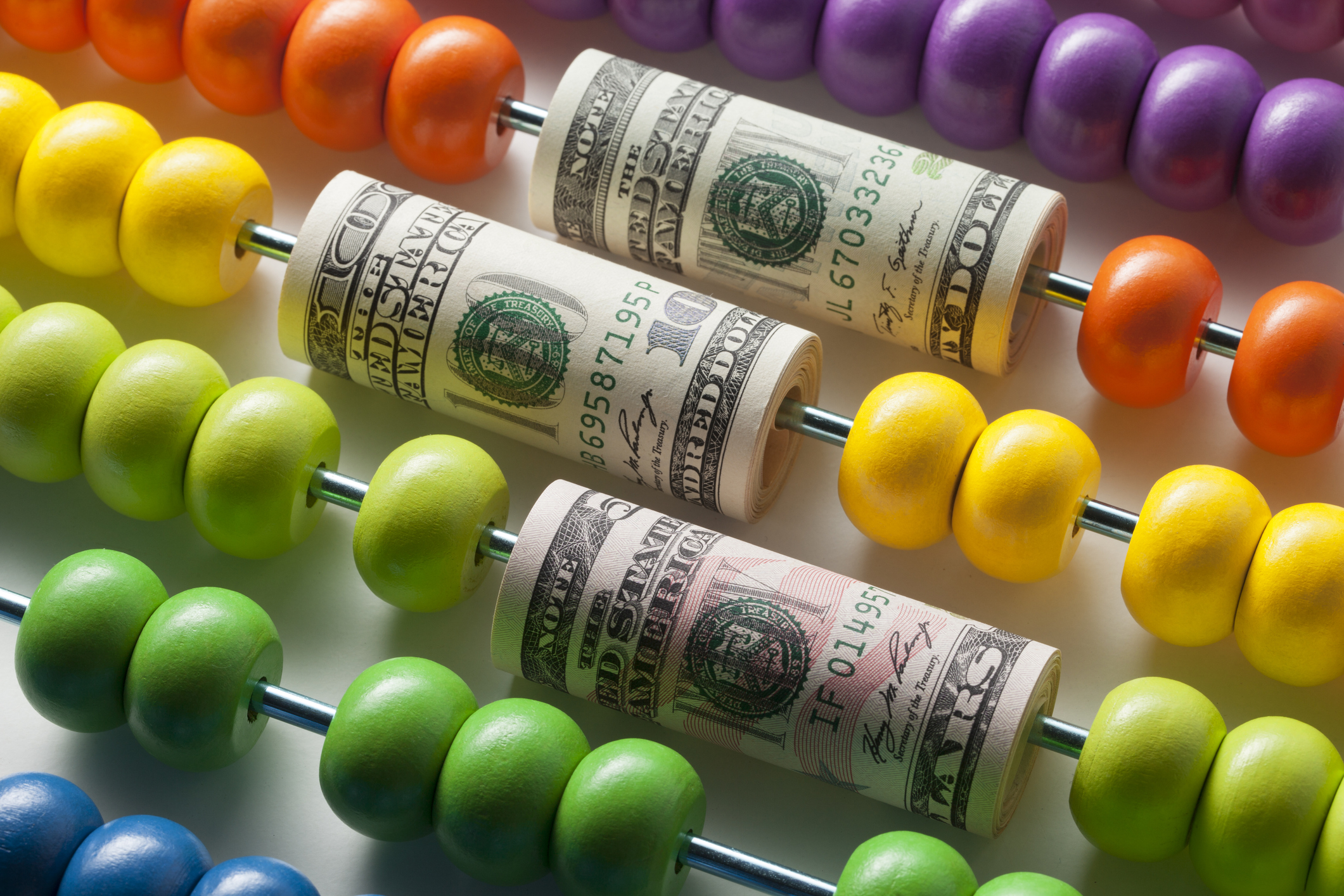 rolls of money on abacus