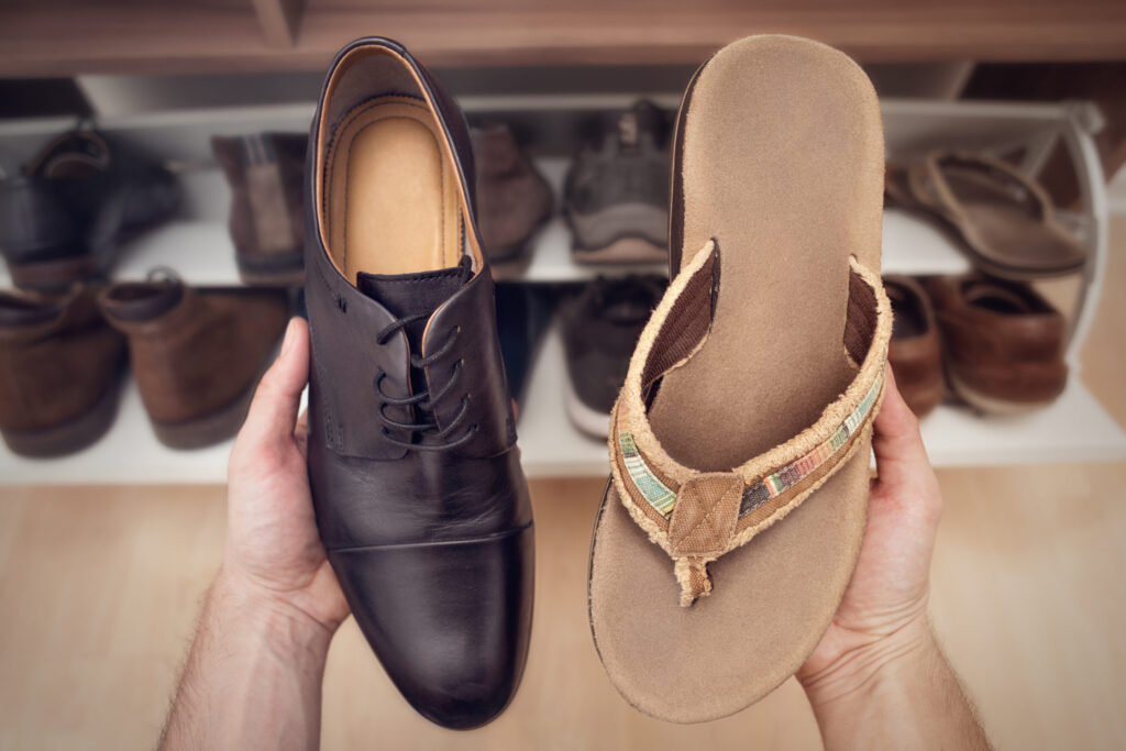 holding one office shoe and one sandal