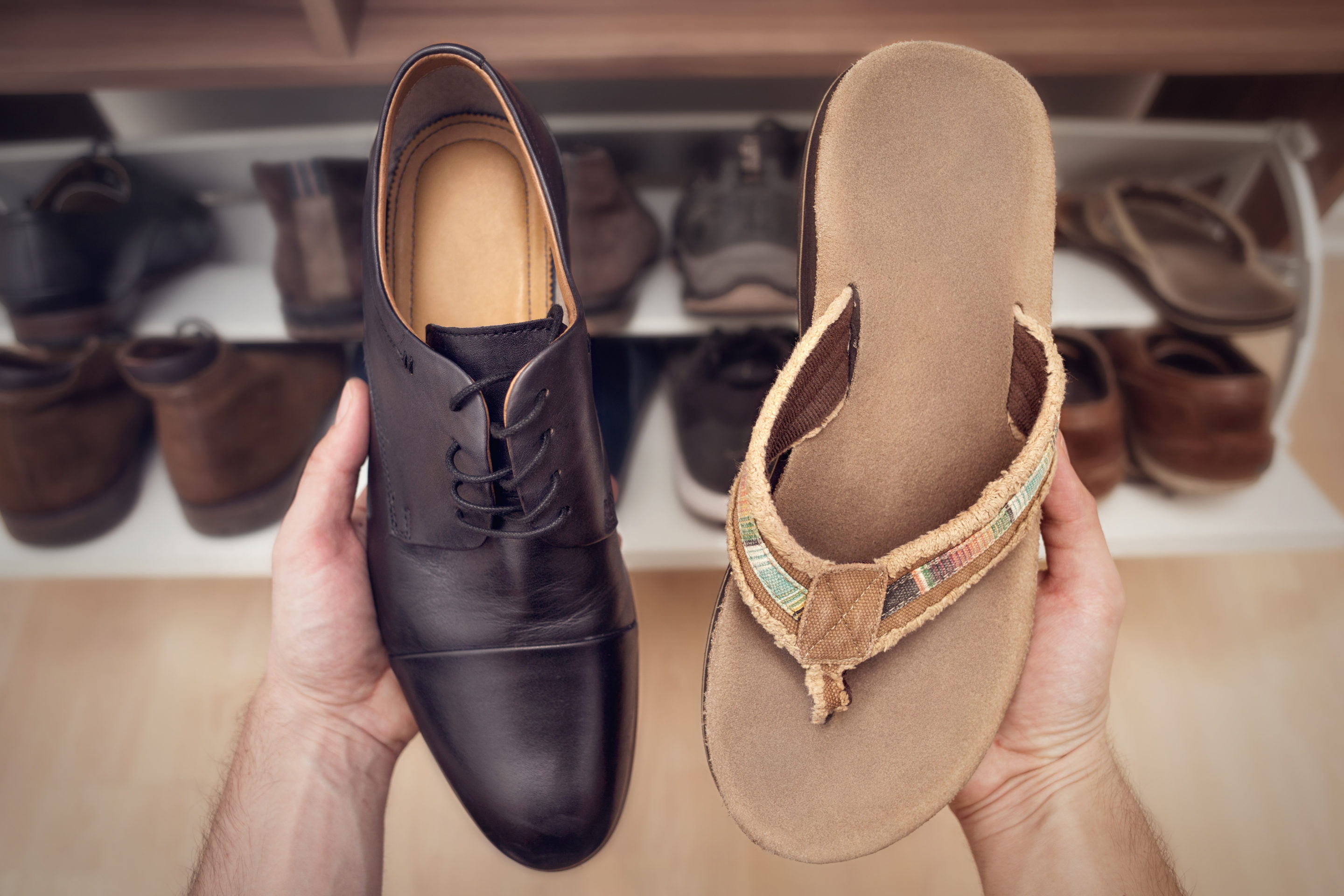 holding one office shoe and one sandal