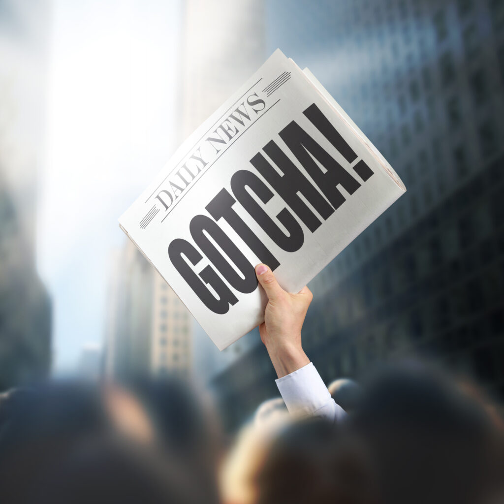 newspaper held up with headline "Gotcha!"