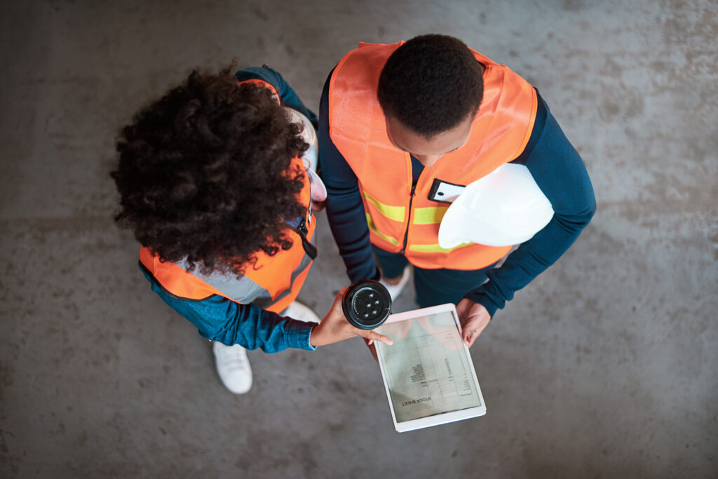 overhead view of workers consulting tablet