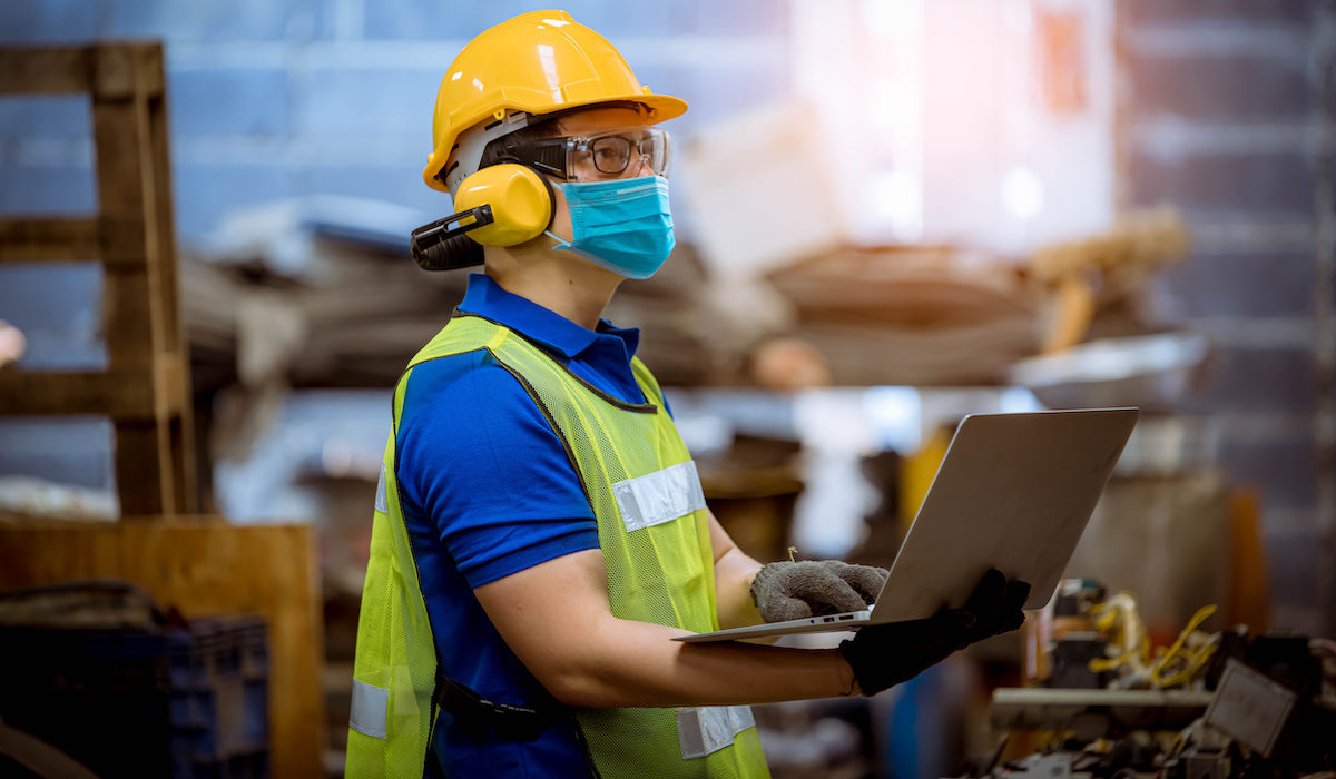 Portrait man worker under inspection and checking production process on factory station by wearing safety mask to protect for pollution and virus in factory.