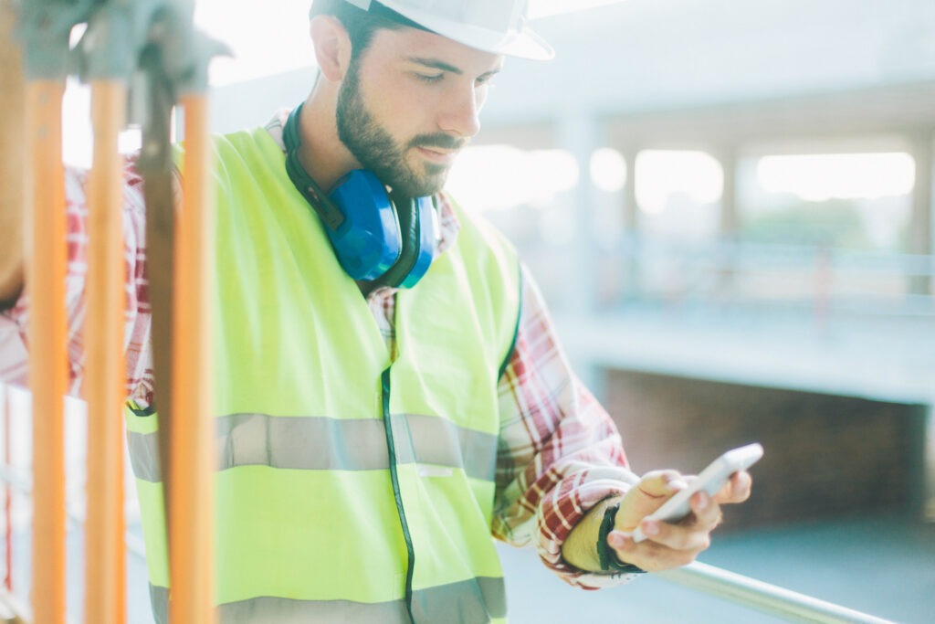 Land surveyor using app on smart phone.